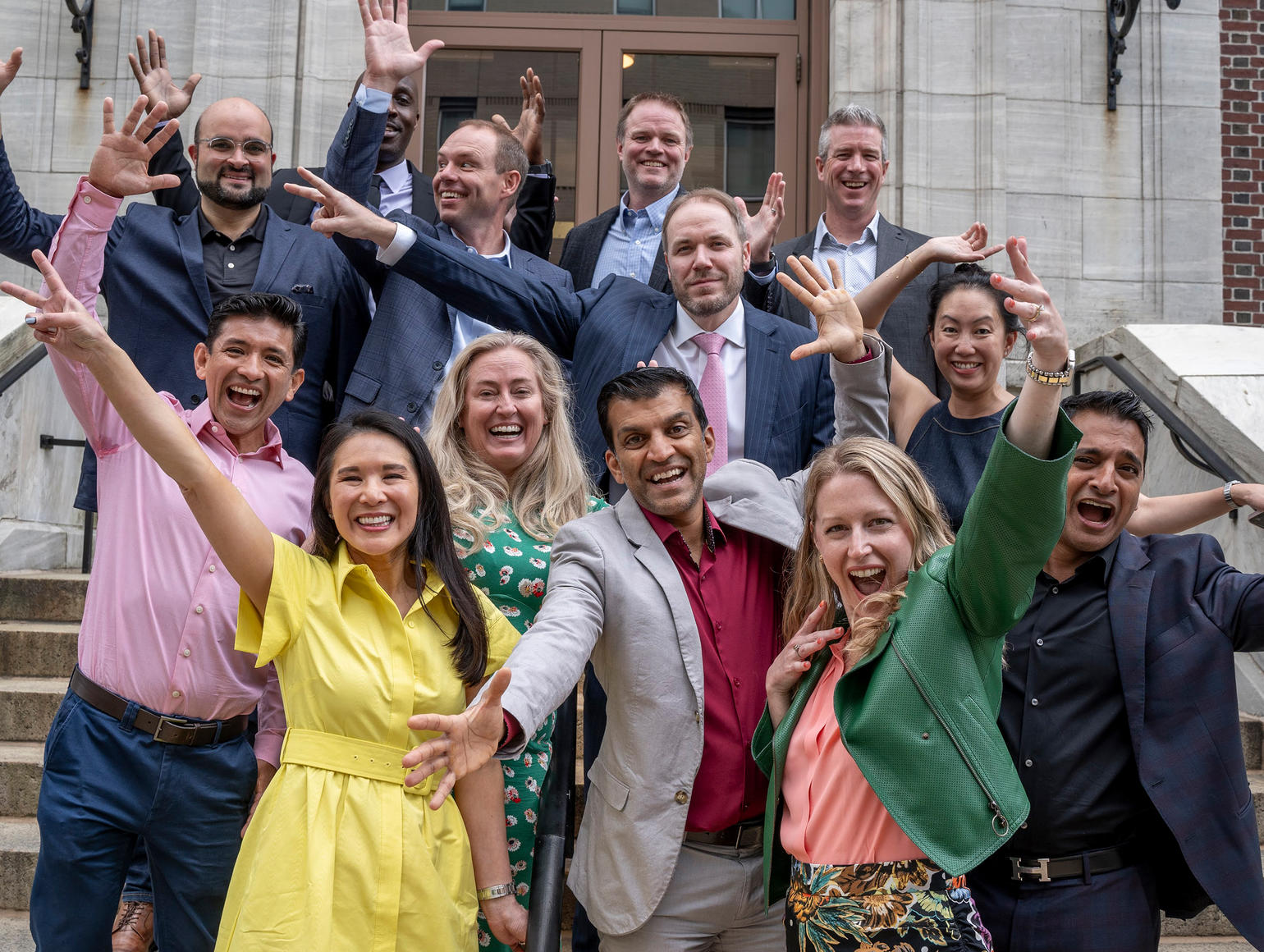 alumni posing at the main building entrance