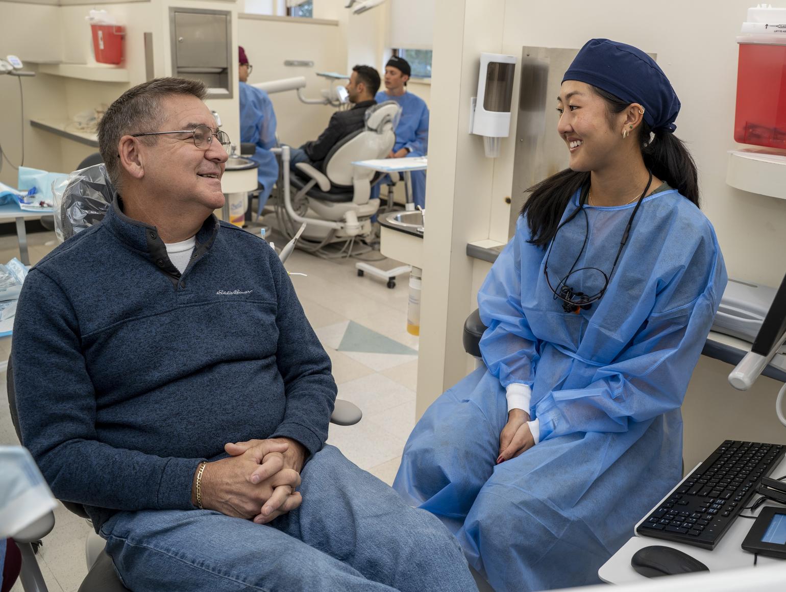 A Harvard Dental Center provider speaks with a patient in the clinic.
