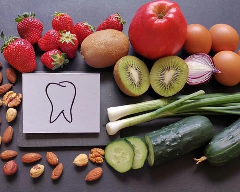 fruits and vegetables surround a sketch of a tooth