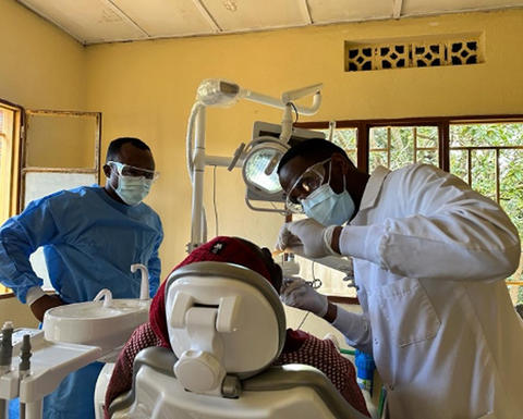 clinicians working on a patient in a Rwandan dental clinic