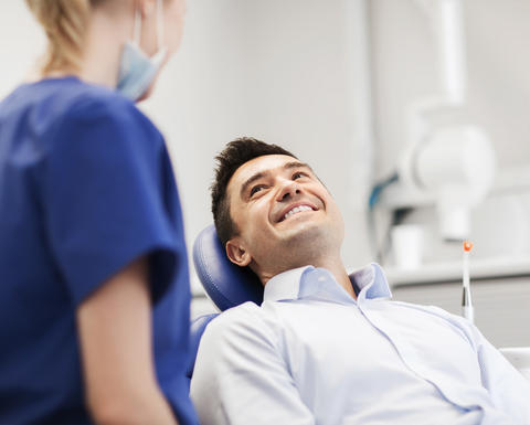 dentist talking with patient in chair