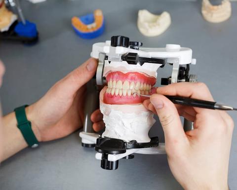 dental technician works with dental prostheses and creates a natural gum