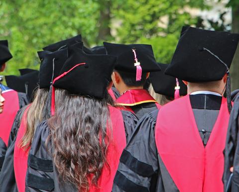 a back view of students in regalia