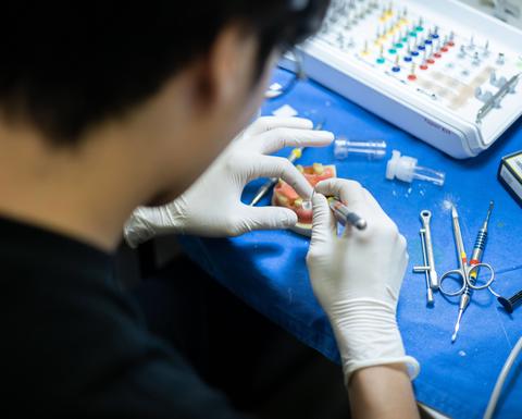 student working on a dental model