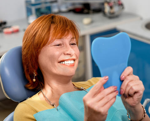 woman smiling looking into a mirror