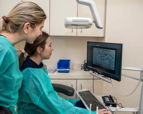 two clinicians looking at a computer screen