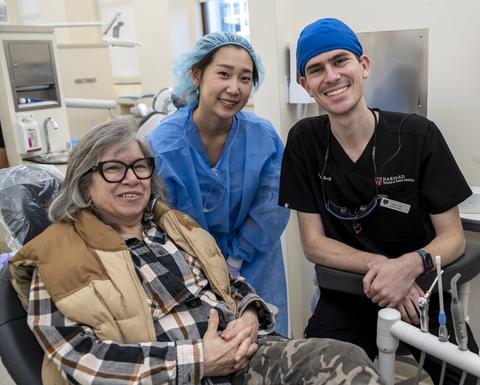 Vet sitting in dental chair with two dental students